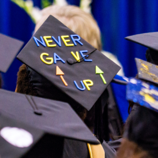 graduation cap with phrase "never gave up"