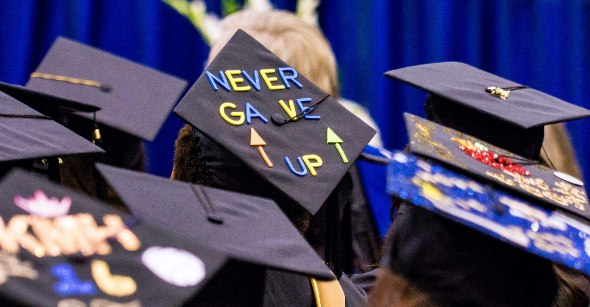 graduation cap with phrase "never gave up"