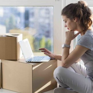 Woman_on_laptop_on_moving_boxes